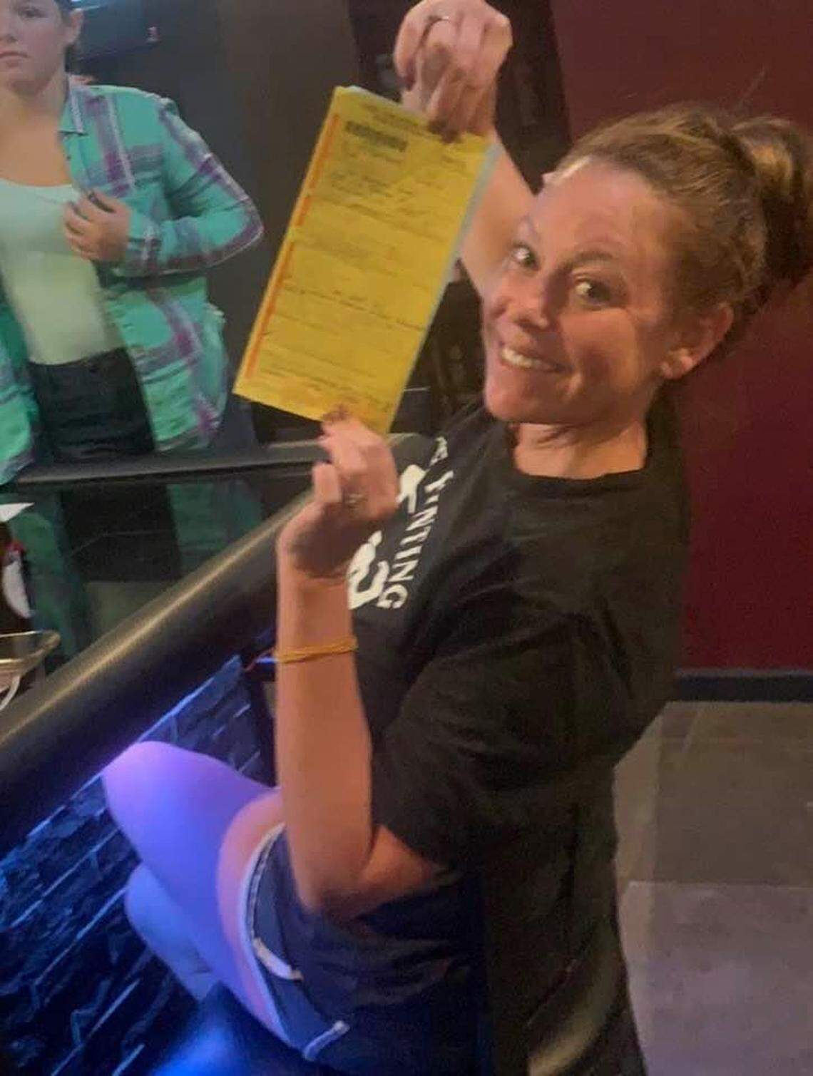 Ashley Driemeyer holds up the ticket she received from the Illinois State Police on Thursday after her restaurant, The Fainting Goat in Pocahontas, continued to serve customers inside despite a state ban on such service.