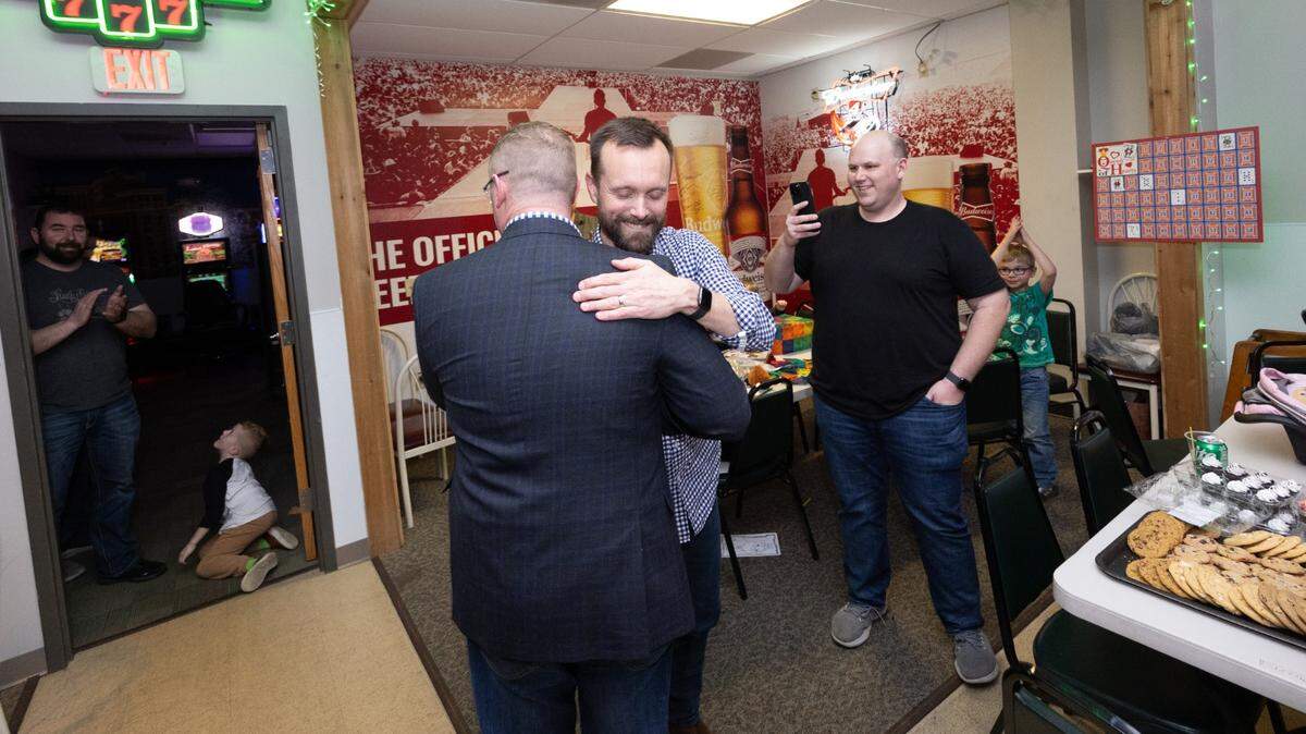 Chris Slusser, center, hugs Patrick McRae at an election watch party on Tuesday night at Wood River Moose Lodge 1349. They had just won their respective primaries, making them Republican nominees for Madison County Board chairman (Slusser) and circuit clerk (McRae).