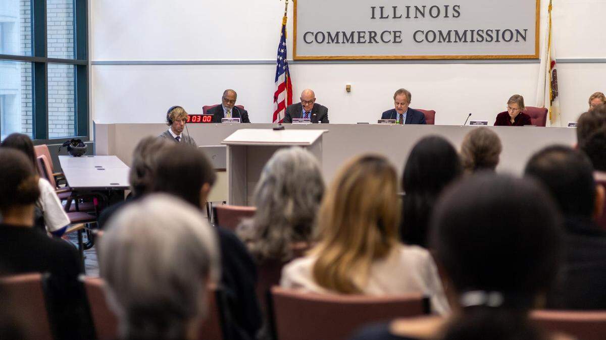 Illinois Commerce Commission Chair Doug Scott is pictured at a packed meeting in Chicago on Thursday as he reads a decision that will limit spending by two major electric utilities. The agency rejected grid plans from Commonwealth Edison and Ameren Illinois.
