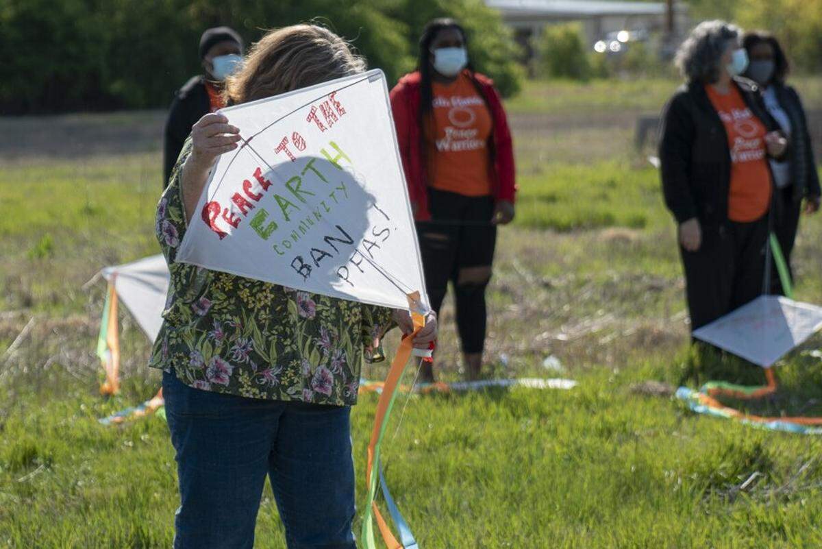 An environmental activist holds a kite with messages supporting a ban on PFAS incineration in front of industrial complexes in Sauget last April. After a similar bill was vetoed last year, environmental groups plan to introduce legislation that would ban the burning of the toxic class of chemicals.