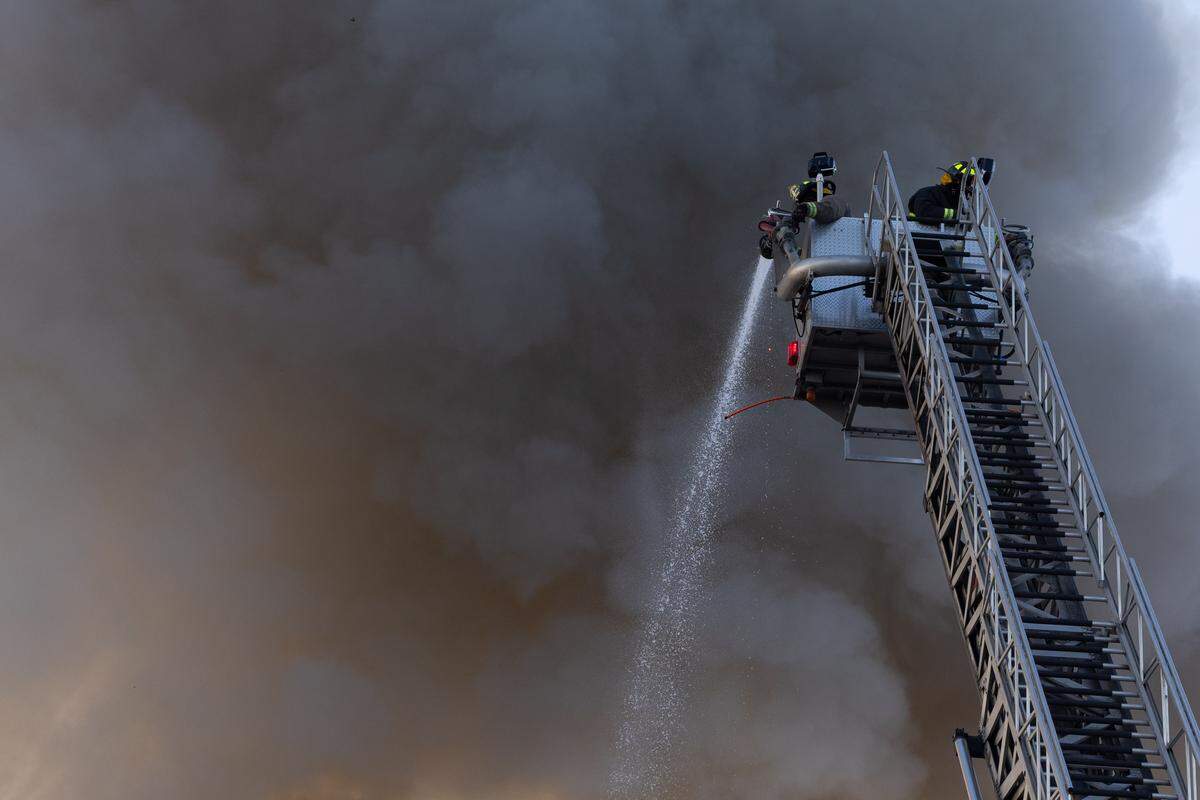Firefighters spray a house down to the scene of a fire on the 400 block of Missouri Avenue in East St. Louis on Thursday.
