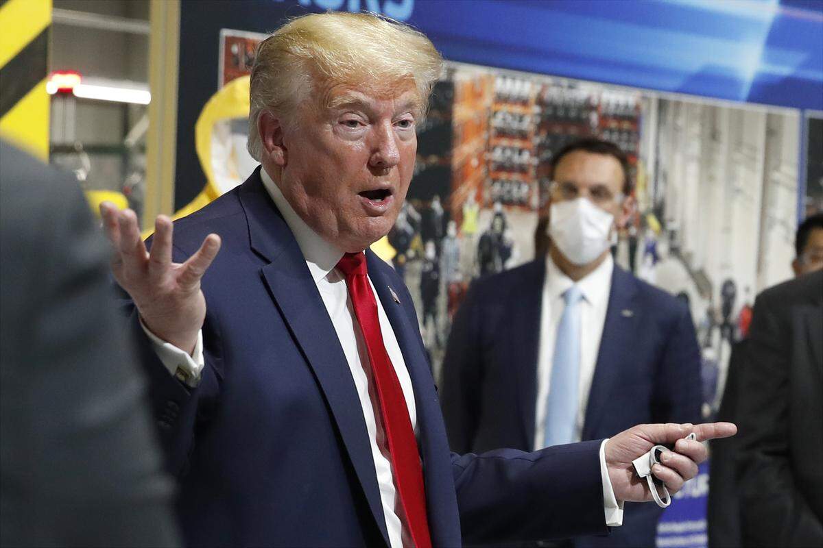 President Donald Trump holds a face mask in his left hand as speaks during a tour of Ford’s Rawsonville Components Plant in Michigan on May 21. The plant is making personal protective equipment.