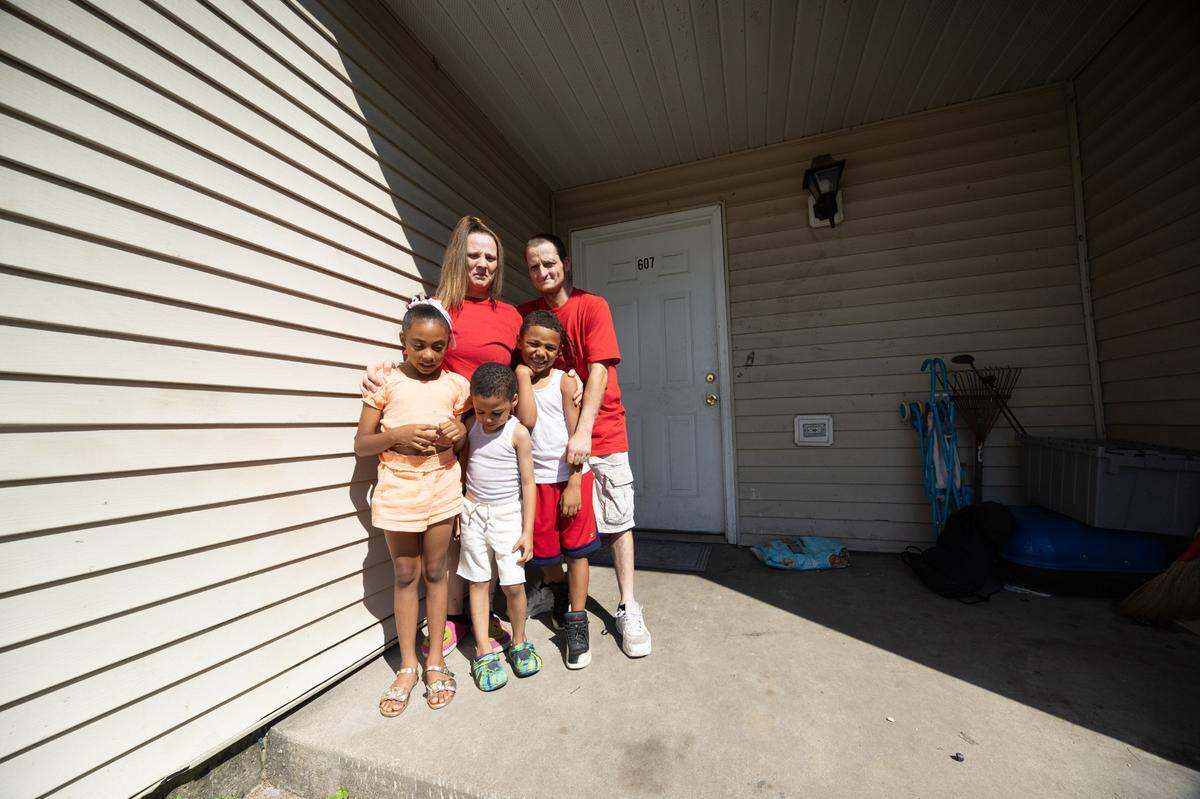 Vikki Monroe stands alongside her brother Michael and her three children outside of her home at Centreville Courts. Among other problems, Vikki Monroe says management has ignored her requests to repair her air conditioner, resulting in high temperatures inside her home.