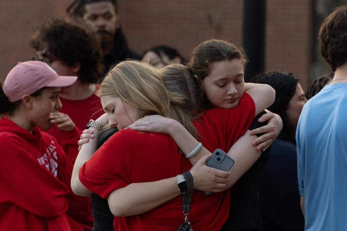Belleville East students hug each other after a balloon release honoring fellow student Jarod Rhodes, who passed away unexpectedly last Friday.