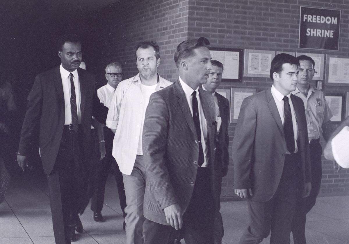 This 1969 photo shows police escorting Marshall Wayne Stauffer, a nomadic mobile-home repairman accused of two murders, two rapes and an armed robbery.