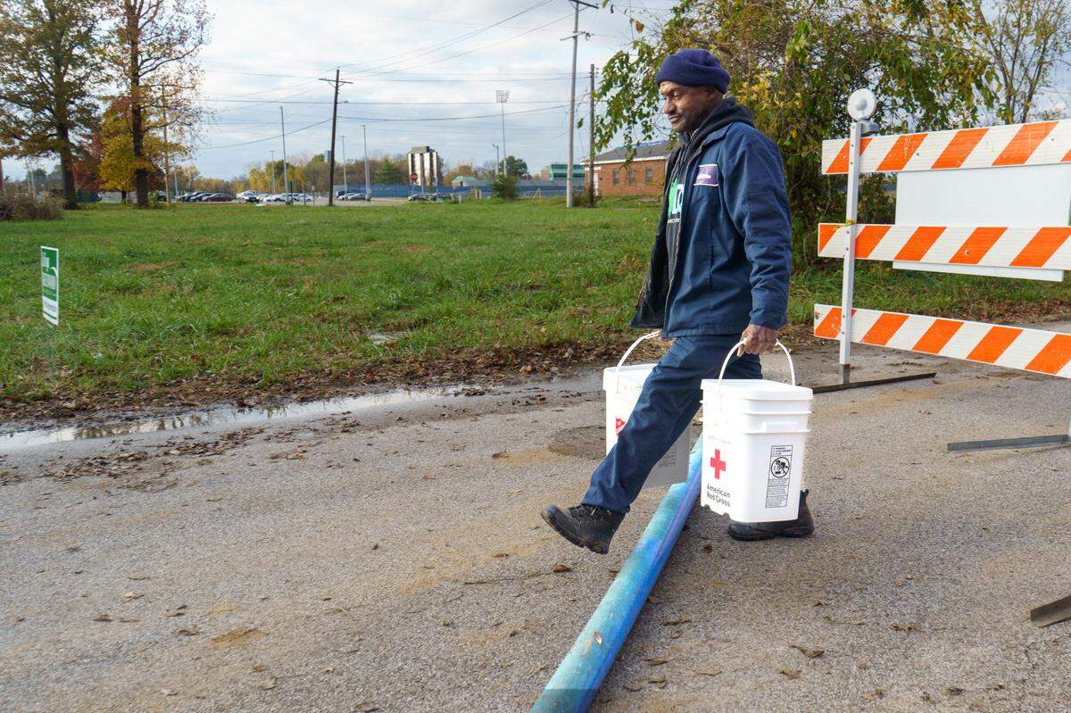 Tony Collins, supervisor in the Public Works Department for the city of East St. Louis, carries clean up kits of aftermath flooding to give to the neighbors in East St. Louis, IL on Wednesday, Nov. 6, 2024.