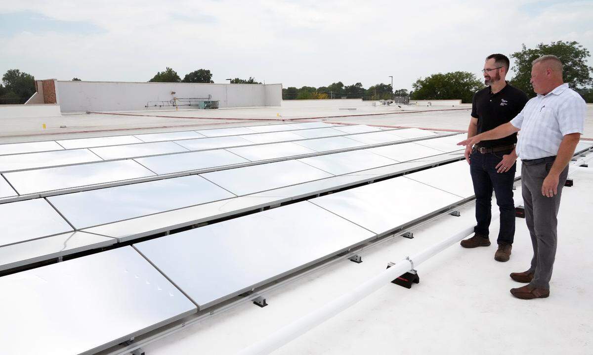 Ike Eichenlaub, Manager HVAC/R & Energy for Schnucks Markets, pointing, and Tom Tyler, industrial energy advisor, Ameren Illinois, on top of the roof at the Fairview Heights Schnucks store. The two are looking at the first installation in the state of Illinois of a radiative cooling technology that is energy efficient. The array of panels integrates with the store’s existing cooling systems. Layered, radiative cooling films on the panels act like a mirror, reflecting up to 97% of sunlight back into the atmosphere. By cooling the fluids used in air conditioning and refrigeration systems, the SkyCool System improves the operating efficiency of the units by as much as 40%.
