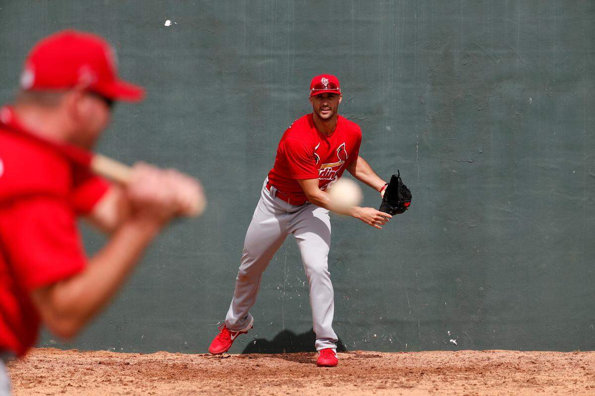St. Louis Cardinals pitcher Jack Flaherty, right, works on fielding a ball hit back to him by bullpen coach Bryan Eversgerd during spring training baseball practice Sunday, Feb. 16, 2020, in Jupiter, Fla. (AP Photo/Jeff Roberson)