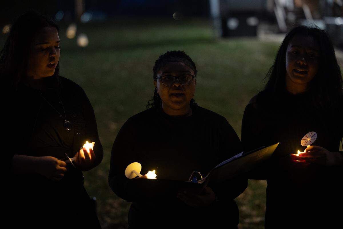 (Left to right) Belleville West students Isabella Russell, A’nyla Miller and Lariel Rayford sing Christmas carols prior to the start of the ceremony.