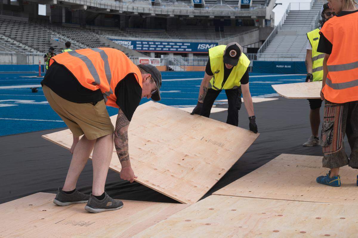 Crews work to place a protective layer over The Blue before laying dirt atop it at Albertson Stadium ahead of the Hot Wheels Monster Trucks Live show set for Saturday.