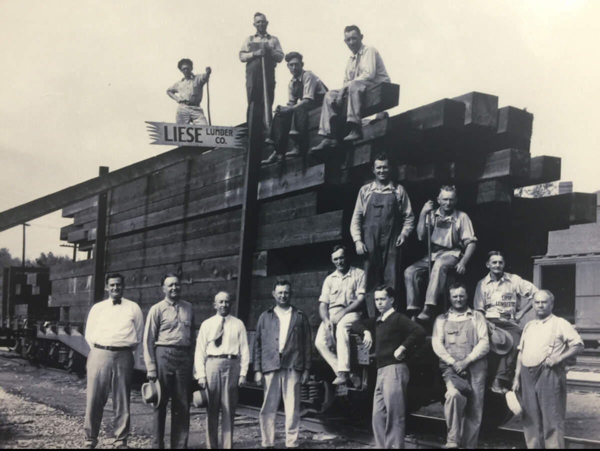 Liese Lumber Co. employees pose for a photo before unloading timbers from a rail car in Belleville in 1930. At left with the bow tie is the late Oscar Lippert, company president.