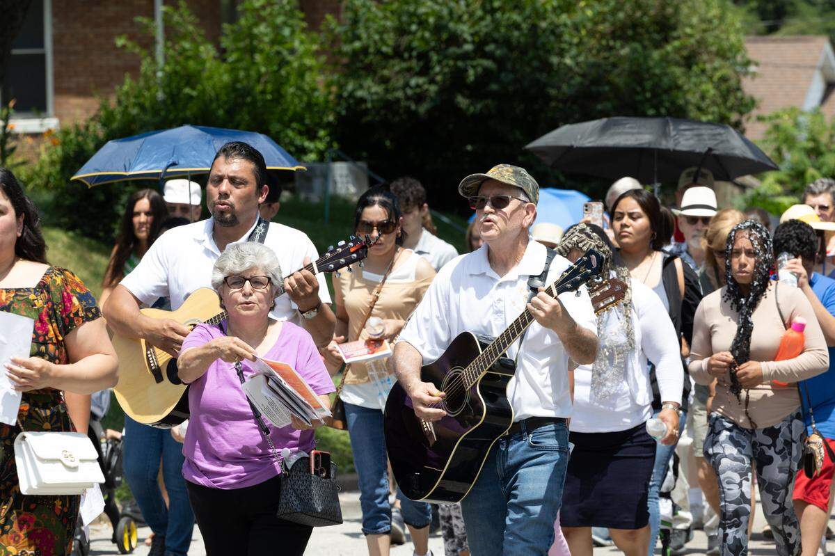 Hundreds of people walk in a procession from St. Peter’s and Paul’s Catholic Church to a nearby cemetery of the same name in Collinsville, Ill. on July 8, 2024. Hymns in English and Spanish were sung along the route. The procession is part of a nationwide eucharist pilgrimage, with Catholics traveling from San Francisco to the endpoint of the pilgrimage, Indianapolis, picking up fellow pilgrims along the way.
