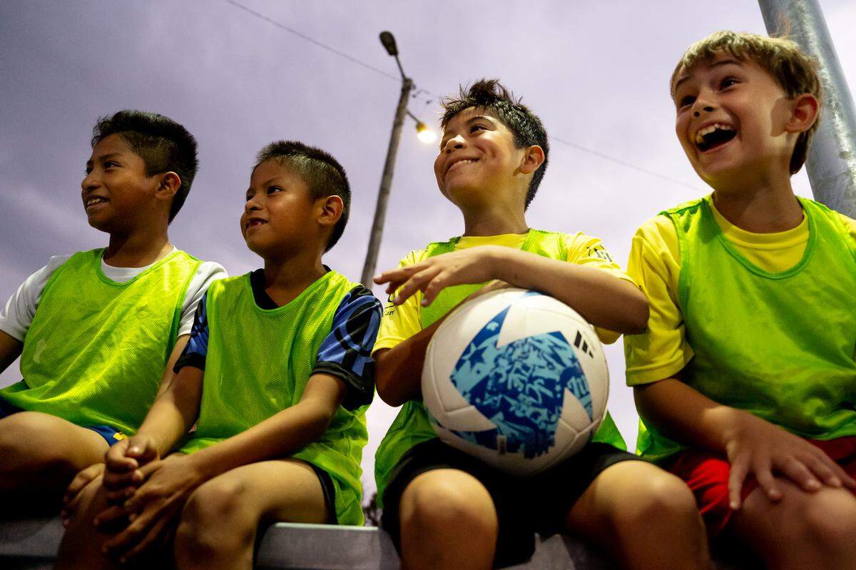 From left: Yahir Morales, 11, Angel Morales, 8, Manuel Tehandon, 8, and Aidan Smith, 9, all of Collinsville, all watch as St. Louis City SC players play soccer with teammates on Thursday, Oct. 26, 2023, during the dedication of a community mini pitch at Granby Park in Fairmont City.