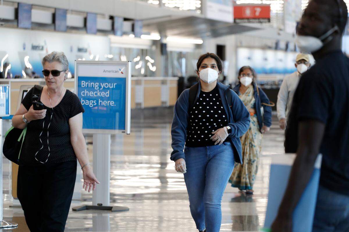 Travelers walk through Terminal 3 at O’Hare International Airport in Chicago on June 16, illustrating the fact that some people feel its important to wear masks to slow the spread of the coronavirus while others feel they are unnecessary.