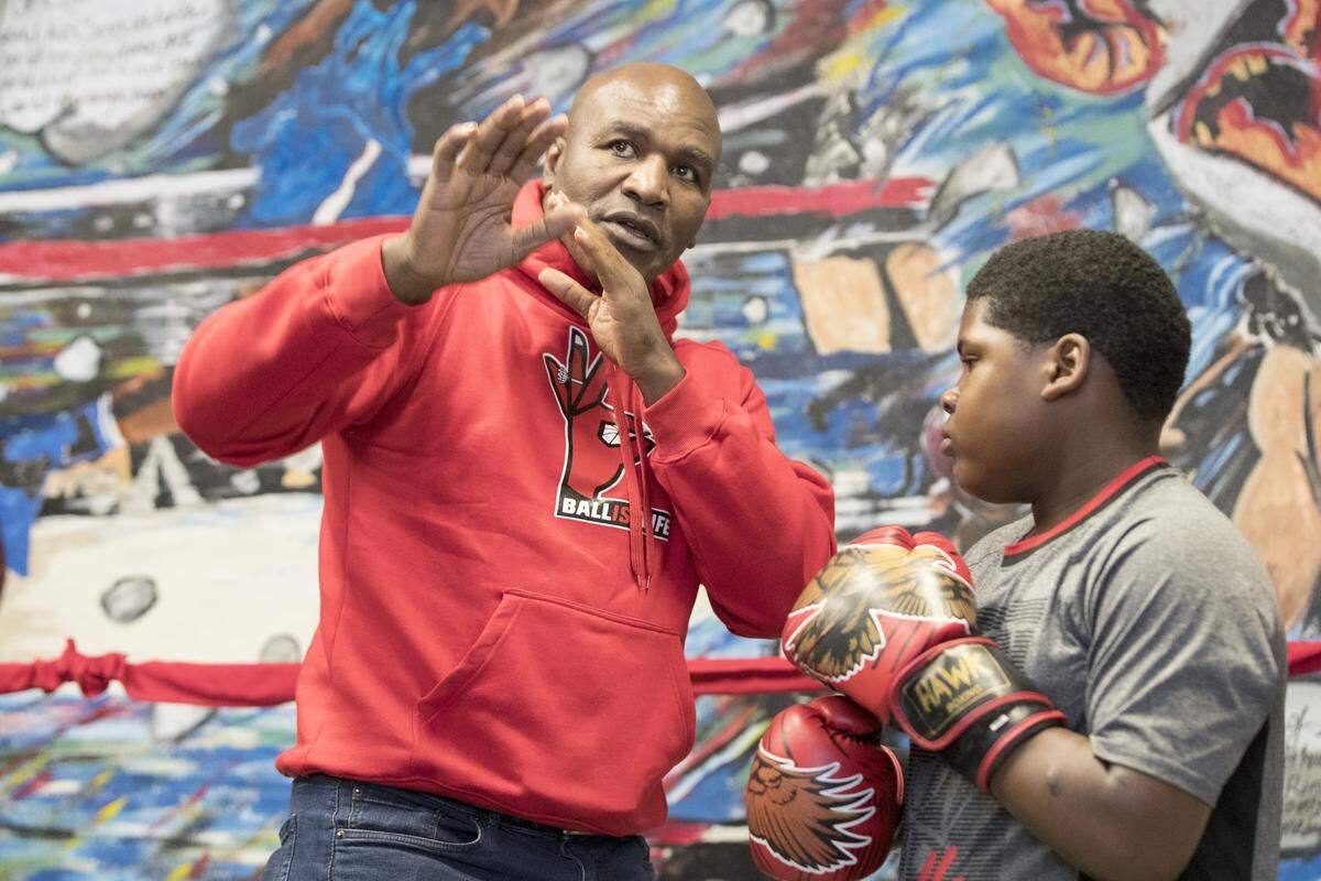 Evander Holyfield works with Lumetrick Rose, 10, of East St. Louis.  Holyfield visited with boxers and supporters of Arthur “Flash” Johnson’s new boxing gym in East St. Louis.