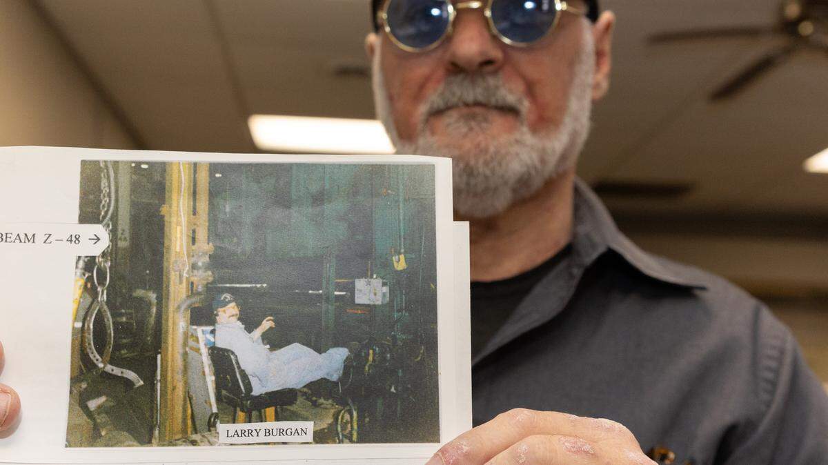 Larry Burgan shows a photo of him in the 1980s working with his feet perched upon a machine while working at the Venice-Madison site when it was owned by Spectrulite Consortium Inc.