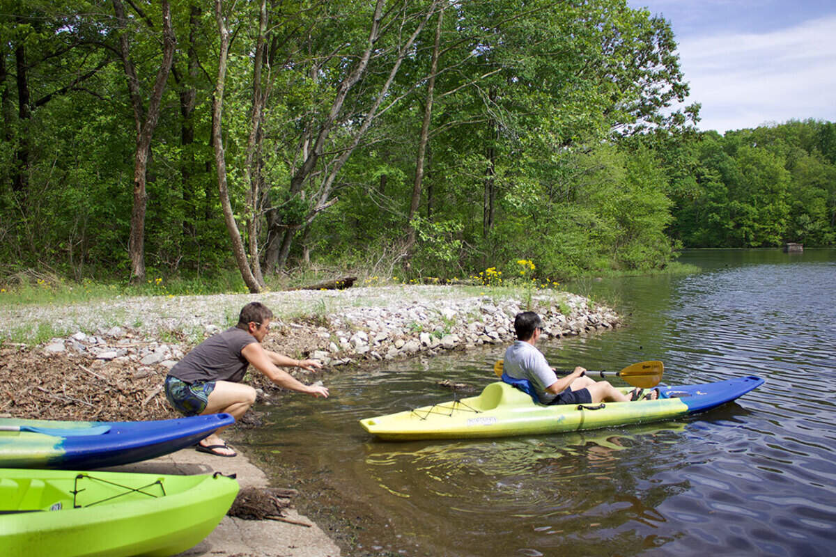 April Peairs gives her wife, Crystal a shove as her kayak glides into their private lake in the Shawnee National Forest on April 26, 2026.
