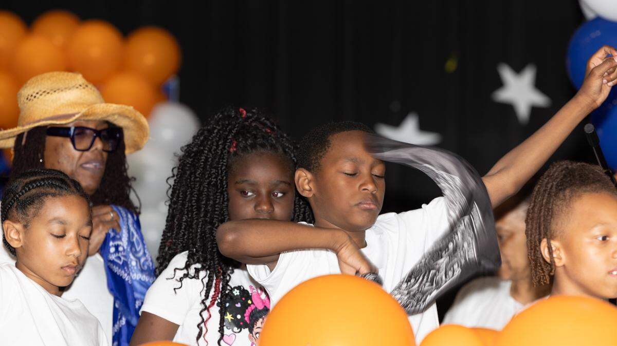 Elementary schoolers sing “Boots on the Ground” in front of a crowd of cheering parents during 2025’s annual “Spring Family Forum,” a showcase for East St. Louis School District 189’s after-school programs. All but two of the schools’ after-school programs closed due to lack of funding. Only Avant and Officer Elementary’s programs are still running, thanks to federal community school grants. But those could soon end, too.