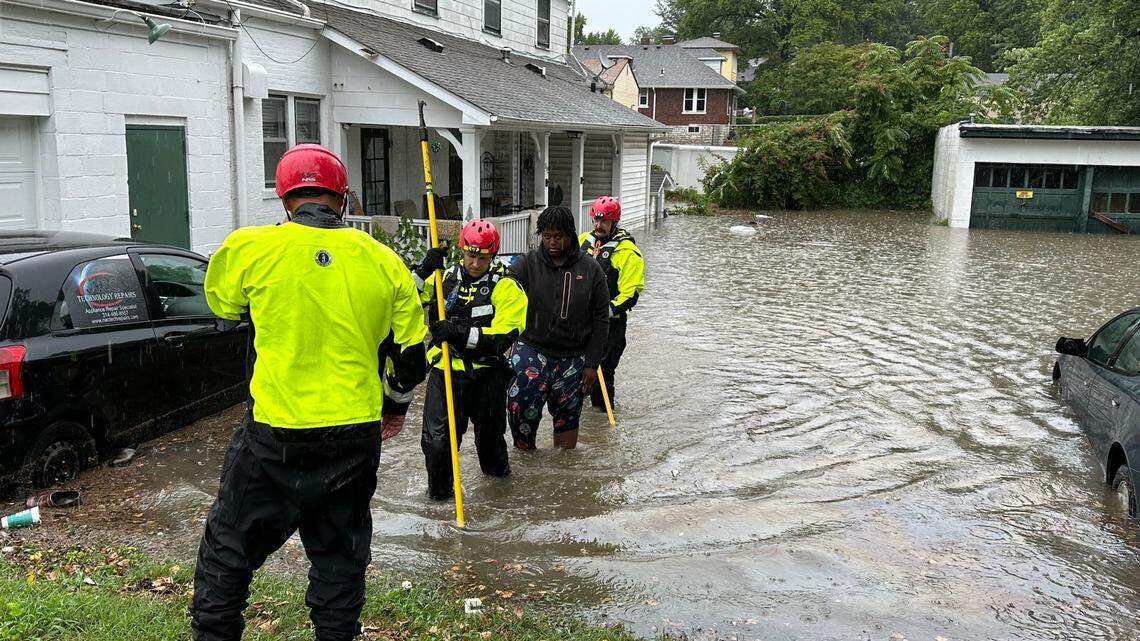 A resident is escorted out of their home through flood water by Belleville firefighters on July 16, 2024.