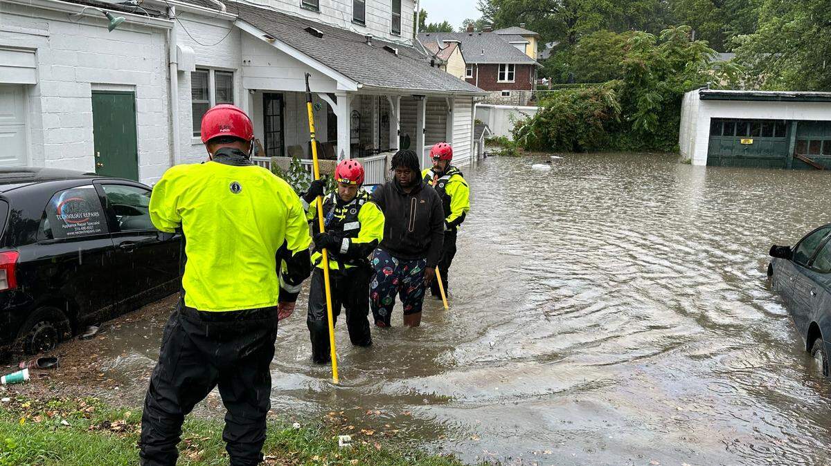 A resident is escorted out of their home through flood water by Belleville Firefighters on July 16, 2024. The home and adjacent business had flooded in just 30 minutes, and the water receded after a City of Belleville worker cleared the backyard sewer drain.