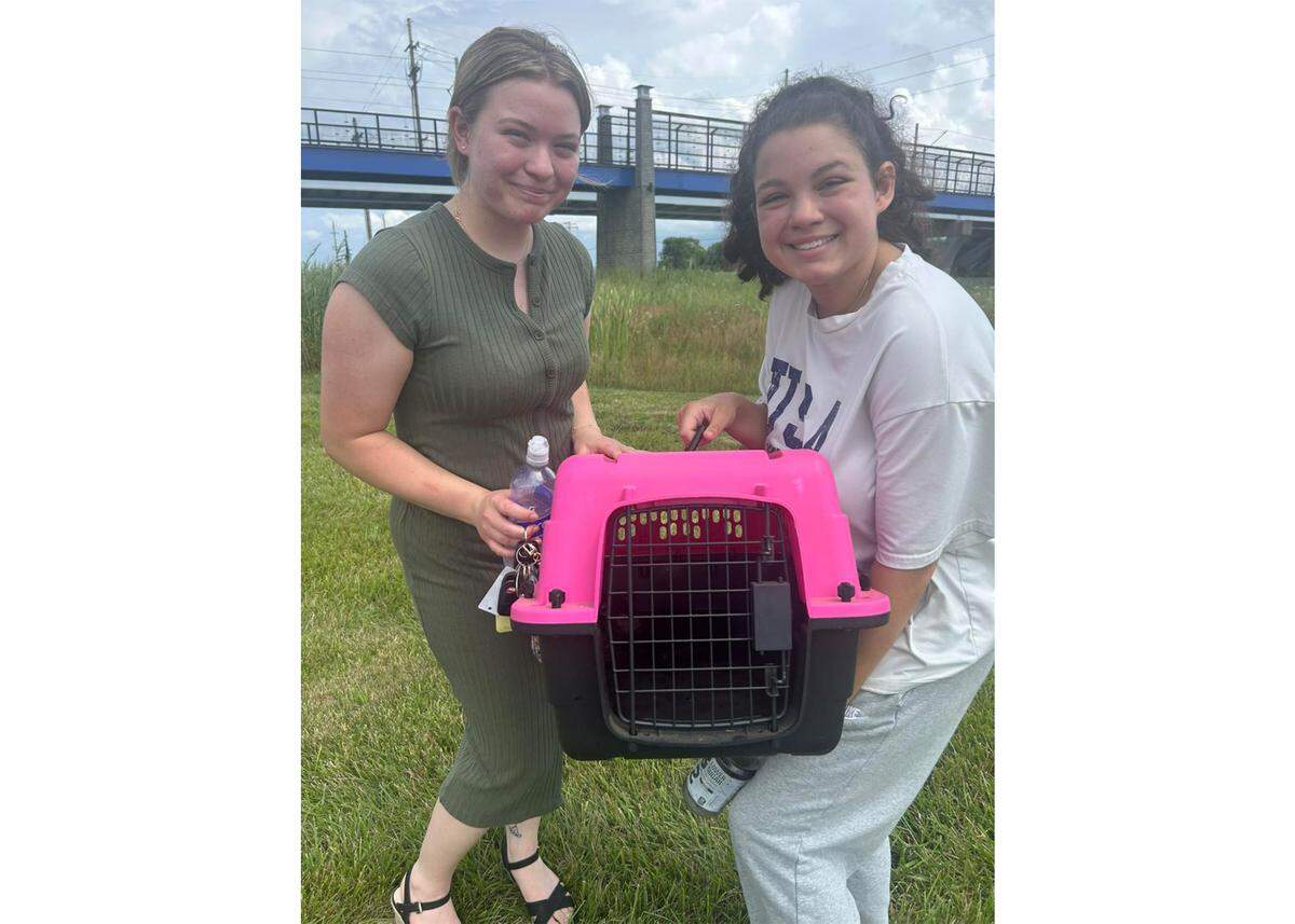Maggie (left) and Cecelia Hammond hold Lombardo, a kitten they found on a Metrolink overpass near SWIC station.