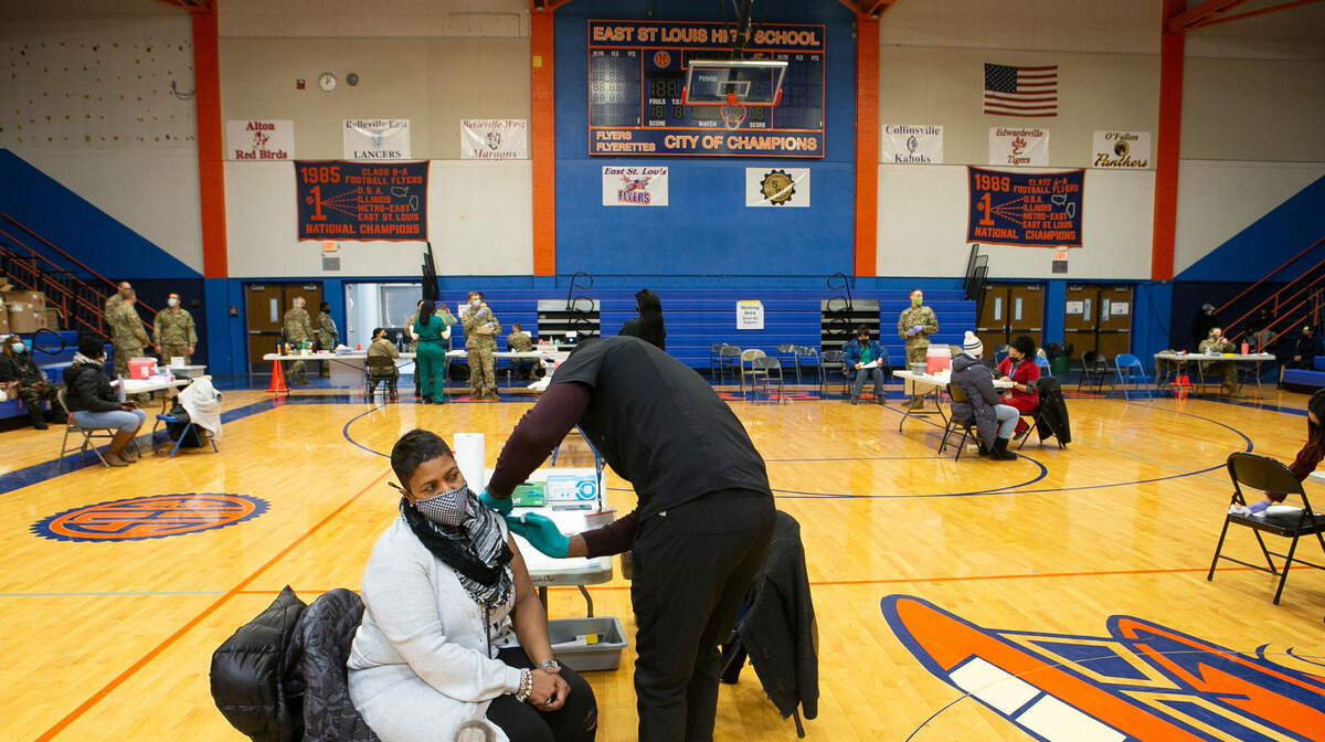 Chantel Crawford, a first grade teacher at Dunbar Elementary School, was in the first round of East St. Louis educators to get vaccinated Tuesday inside the gymnasium at East St. Louis High School.