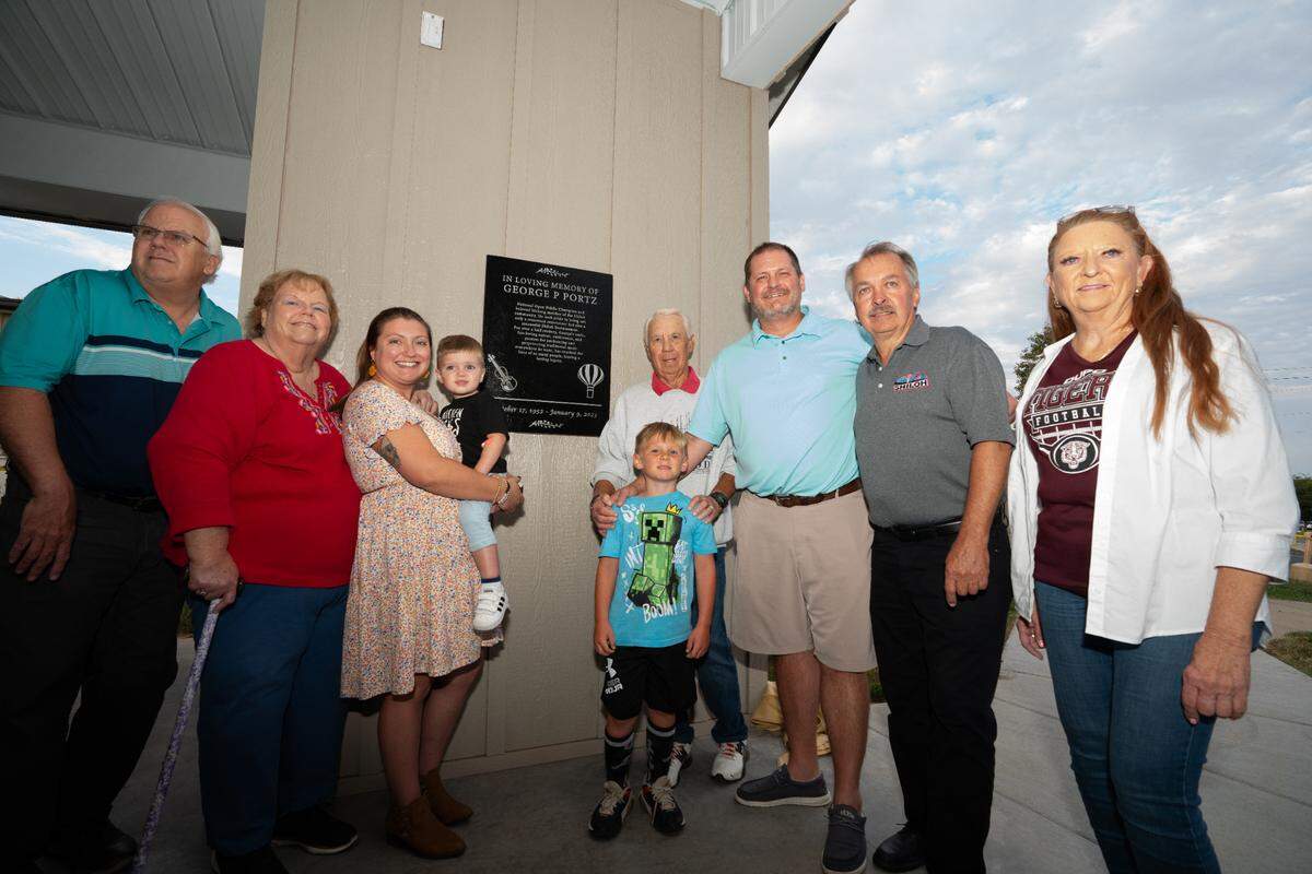 Members of George Portz’s family pose with Mayor Robert Weilmuenster in Shiloh, Ill. next to a plaque to the late businessman and bluegrass musician. Before and after the dedication, members of Portz’s old group played bluegrass songs ranging from John Pine’s “Paradise” to “Will the Circle Be Unbroken.”