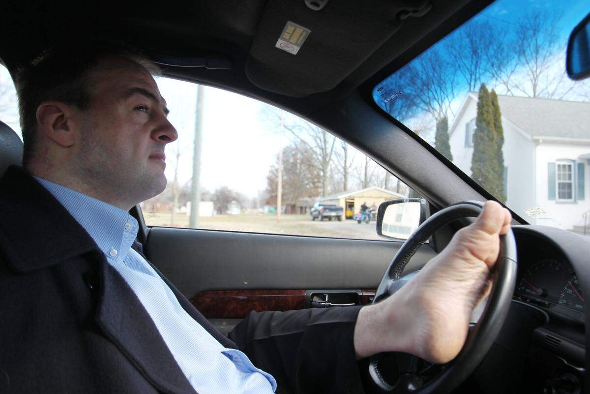 John Foppe heads out to pick up his daughter, Faith, from school. He uses his feet to drive.