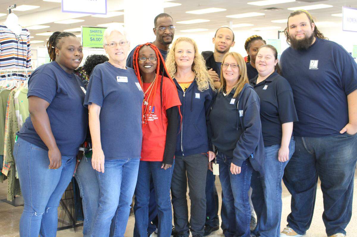 Kristy Lance, center, retail vice present for Metropolitan Employment and Rehabilitation Services (MERS) Missouri of Goodwill Industries, poses with employees at its new Belleville store.
