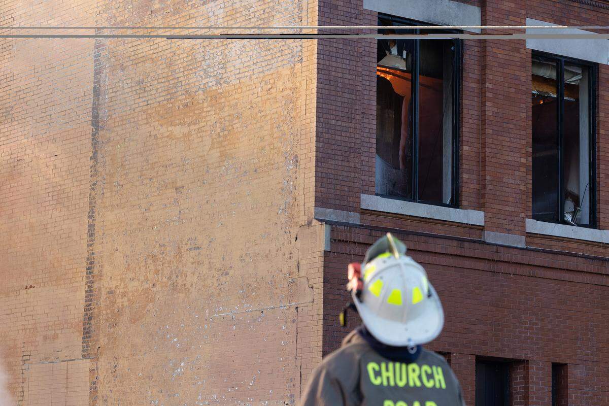 A Church Road firefighter observes as a fire on the 400 block of Missouri Avenue in East St. Louis rages on Thursday.