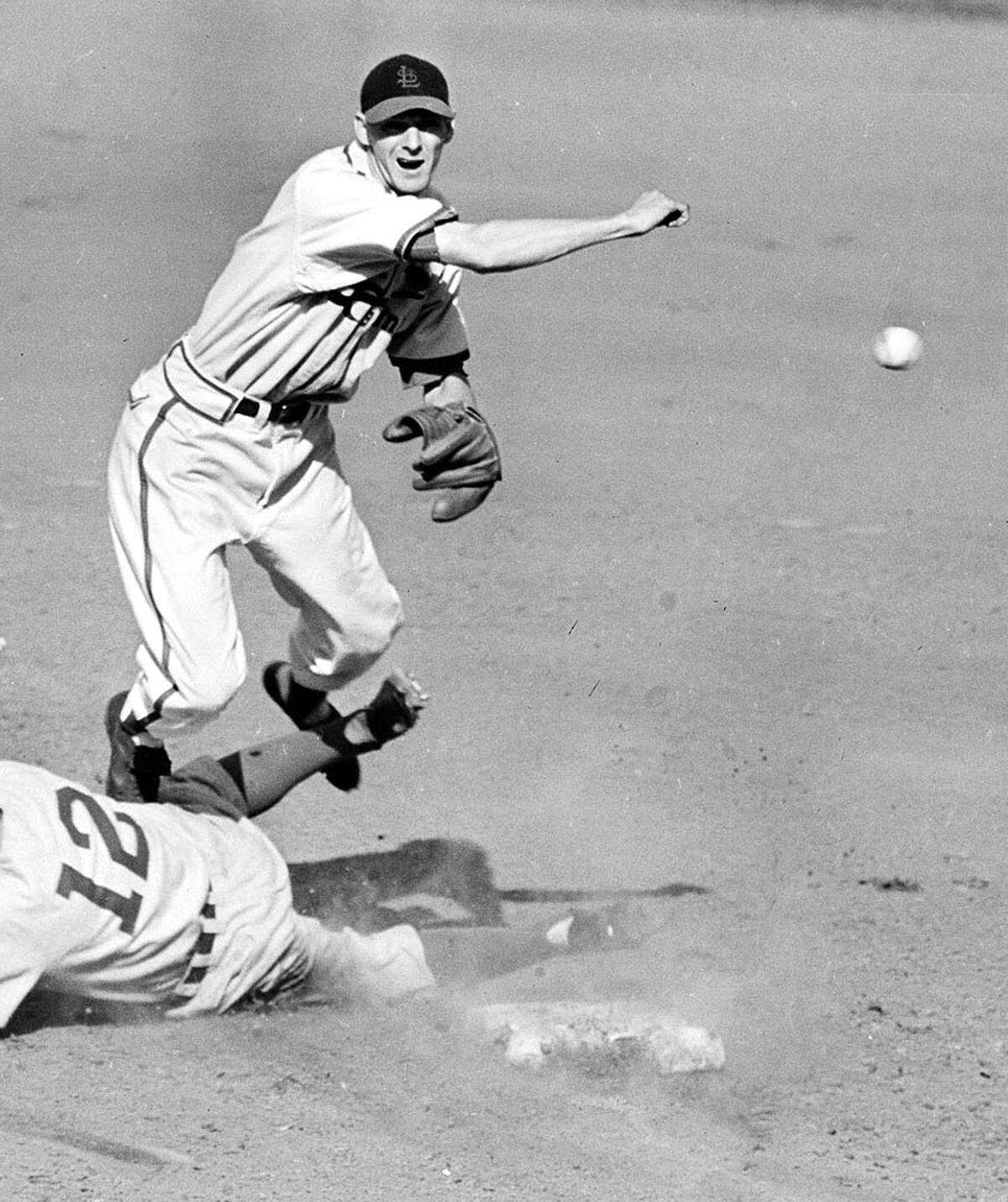 In this Oct. 1, 1946 file photo, St. Louis Cardinals shortstop Marty Marion leaps high to avoid the spikes of sliding Brooklyn Dodgers runner Ed Stanky in the third inning of the first game in the National League tie-breaker series in St. Louis, Mo. (AP Photo/File)