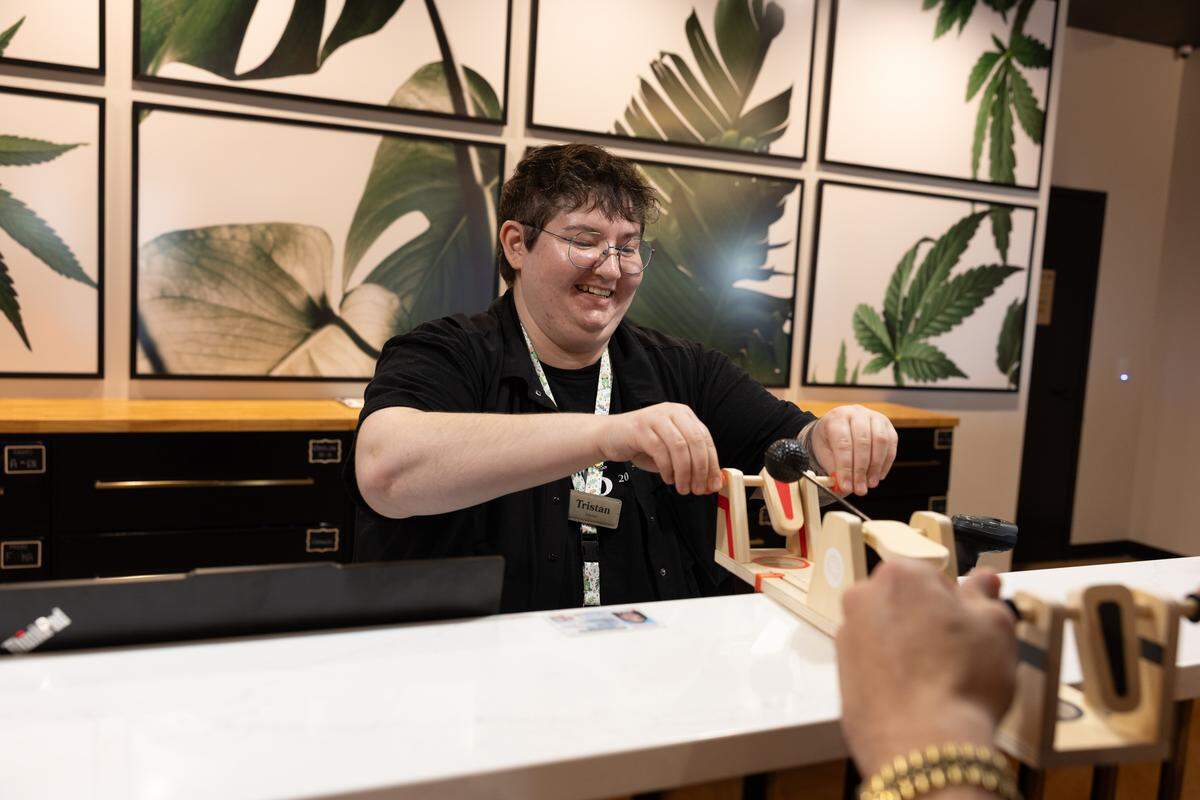 A Market 96 employee plays a game with a customer during checkout. “Cannabis should be fun,” said director of retail operations Dre Trobradovic, “so we try to make it a fun shopping experience too.”