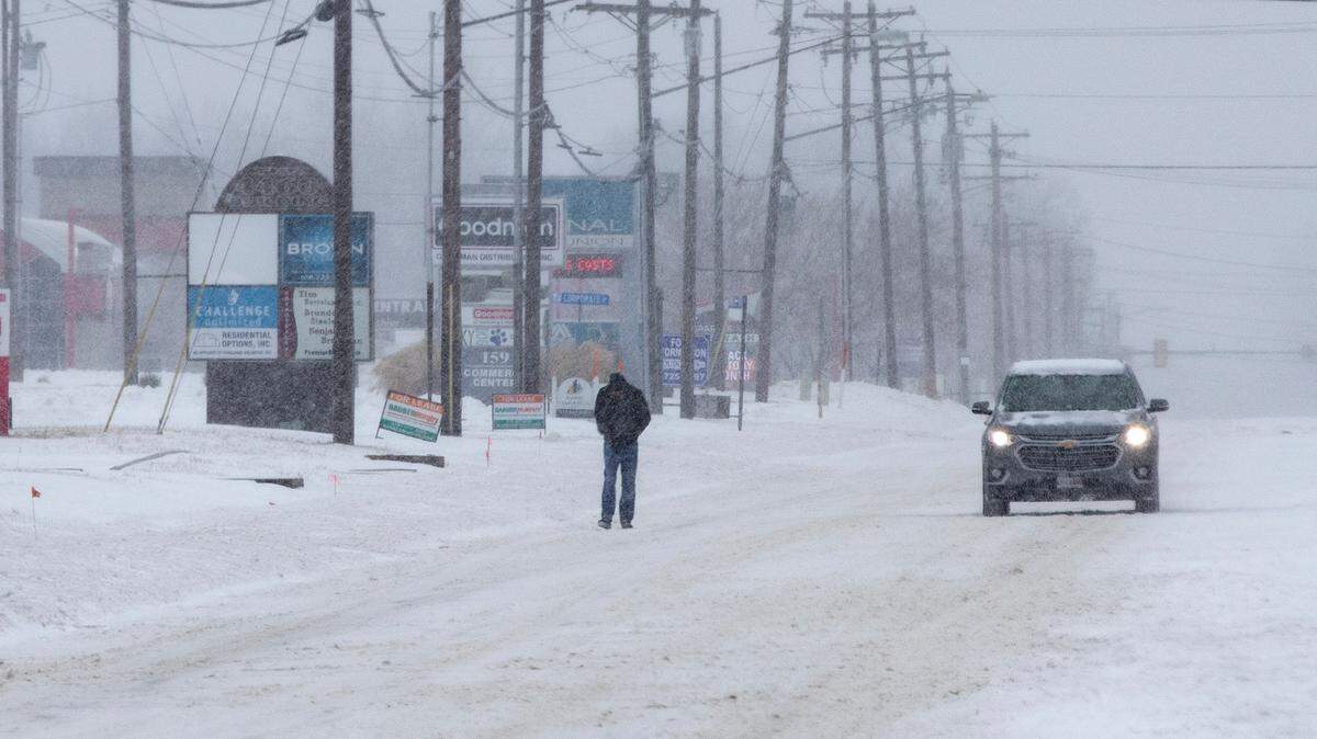 A person avoids the deep snow and walks on Illinois 159 in Swansea Thursday morning.