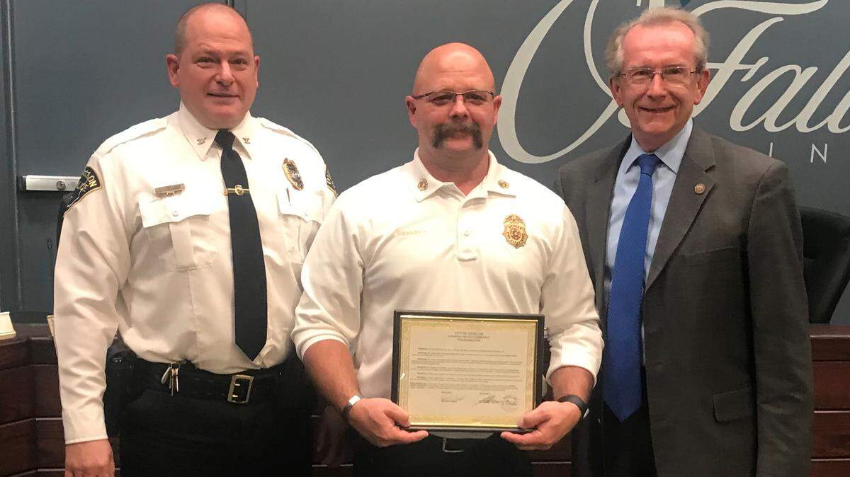 Director of Public Safety, left, and Mayor Herb Roach, right, made a presentation to Fire Chief Brent Saunders, who is vacating the post for a new job in the private sector.