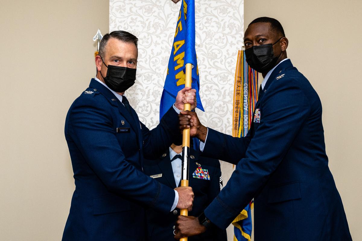 U.S. Air Force Col. Willie L. Cooper, 375th Mission Support Group incoming commander, receives the guidon from Col. Chris Robinson, 375th Air Mobility Wing commander, during the 375th MSG change of command on Scott Air Force Base. The passing of the guidon symbolizes Cooper has assumed command.