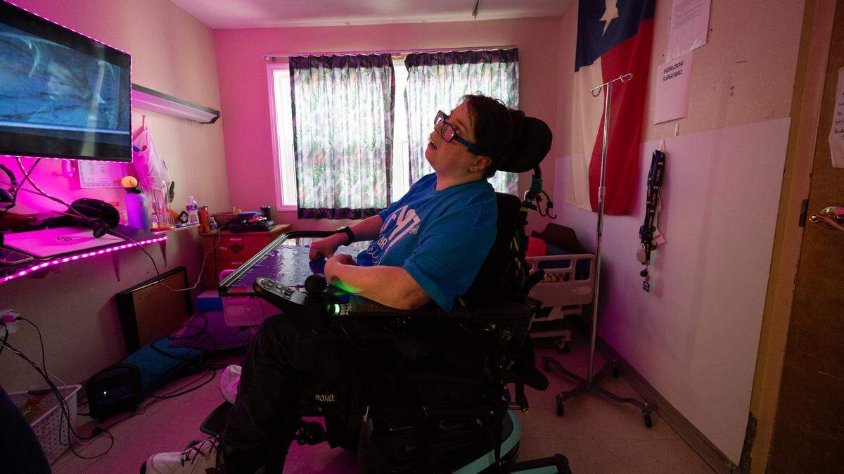 Jennifer Foushee, 40, who has cerebral palsy, has lived at the long-term care facility Clinton Manor Living Center in New Baden for the past 13 years. She personalized her side of a small shared bedroom by hanging neon pink lights and the state flag of Texas, her home state. Now, she fears she may lose her home because of proposed federal cuts to Medicaid, which pays for her care.