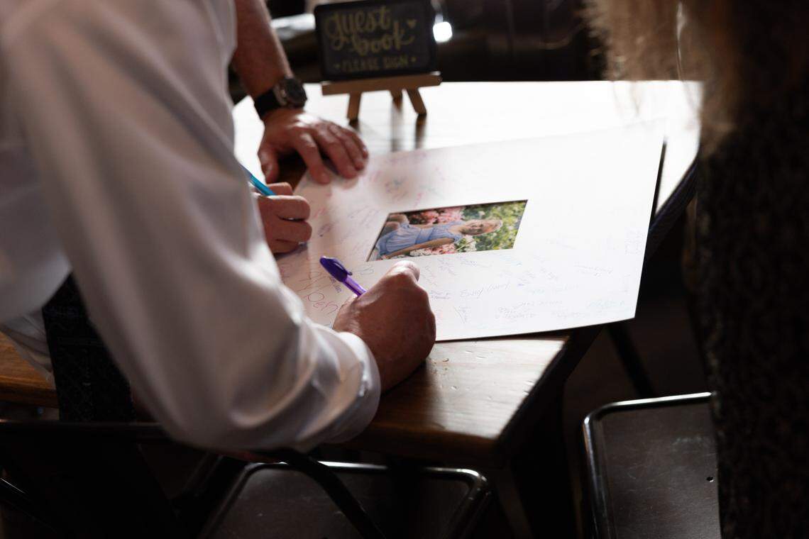 Loved ones of Elsie Wiemerslage sign a visitor board with the late teen’s portrait.