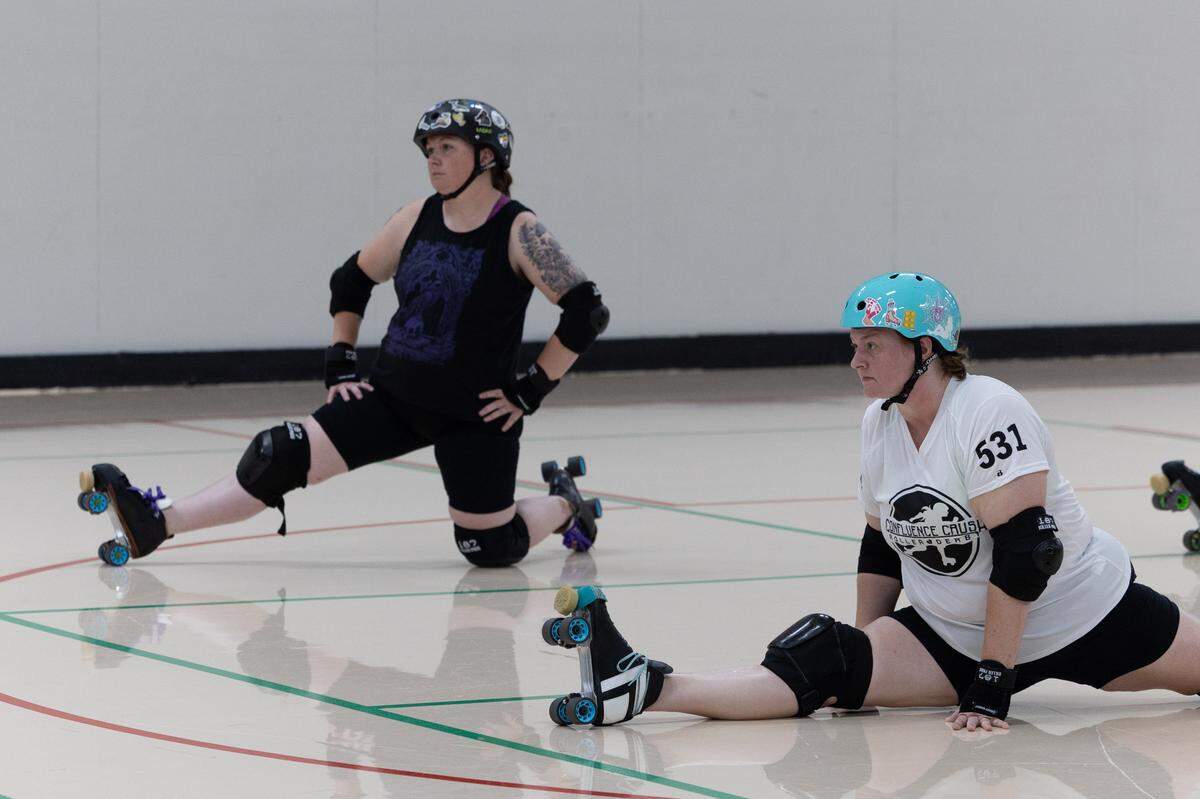 Members of Confluence Crush stretch before practicing at an activity center in Troy.