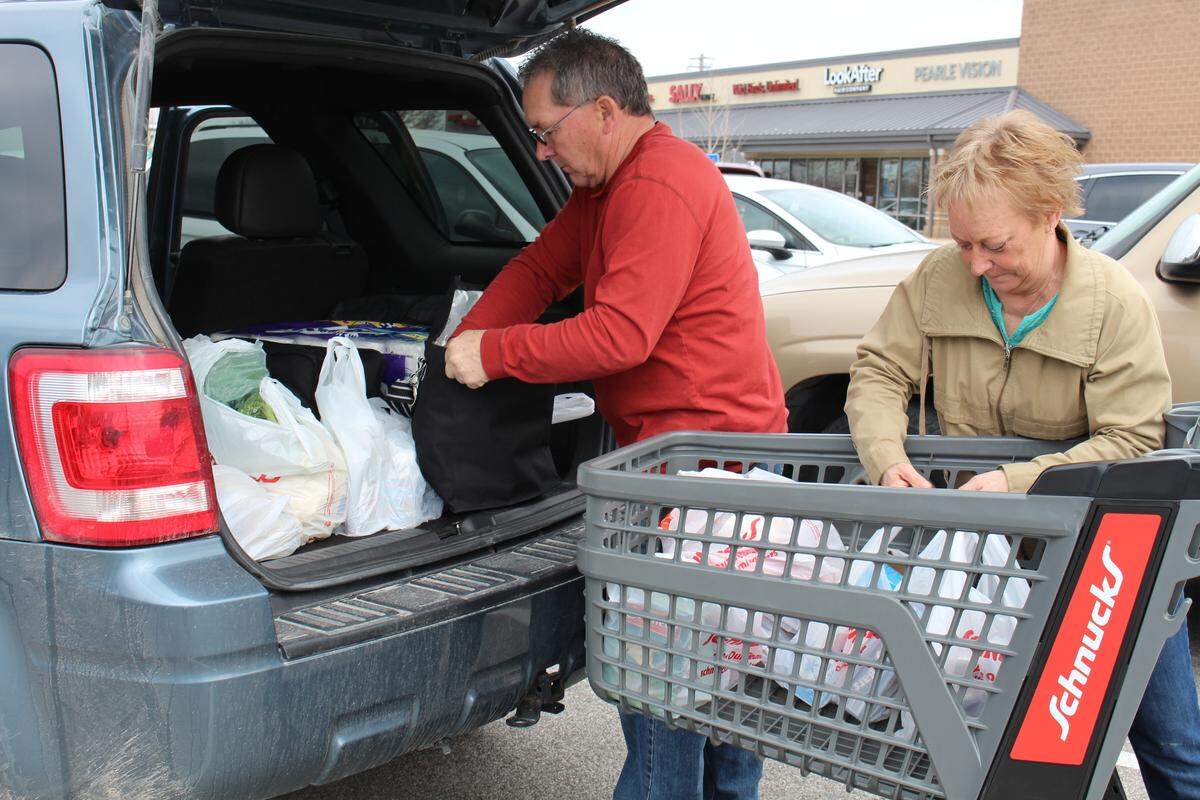 Mike and Vicki Blunt, of New Douglas, load their vehicle with groceries in single-use plastic bags at Schnucks in Edwardsville in March. The couple usually bring their own reusable bags, but on this day, they bought too many groceries and needed more.