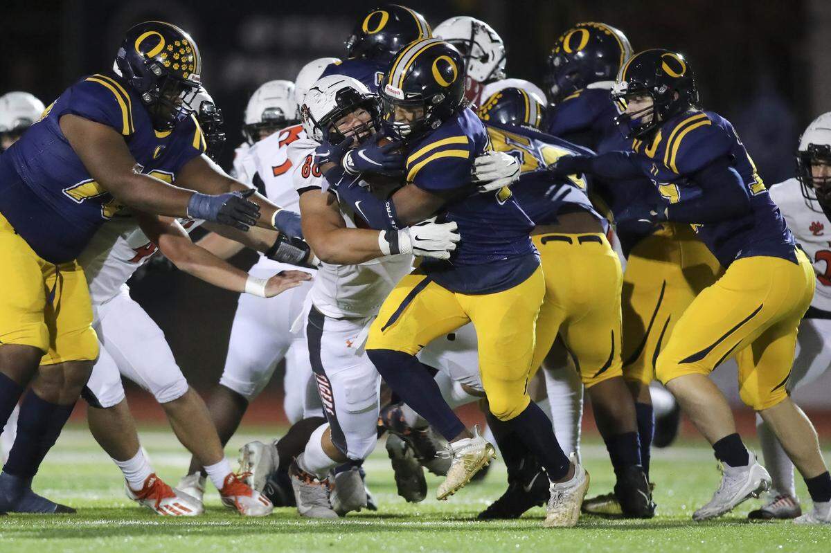 Edwardsville’s Iose Epenesa brings down O’Fallon’s Christopher Caldwell during Saturday night’s IHSA Class 8A playoff game. The Tigers defeated the Panthers 43-36.