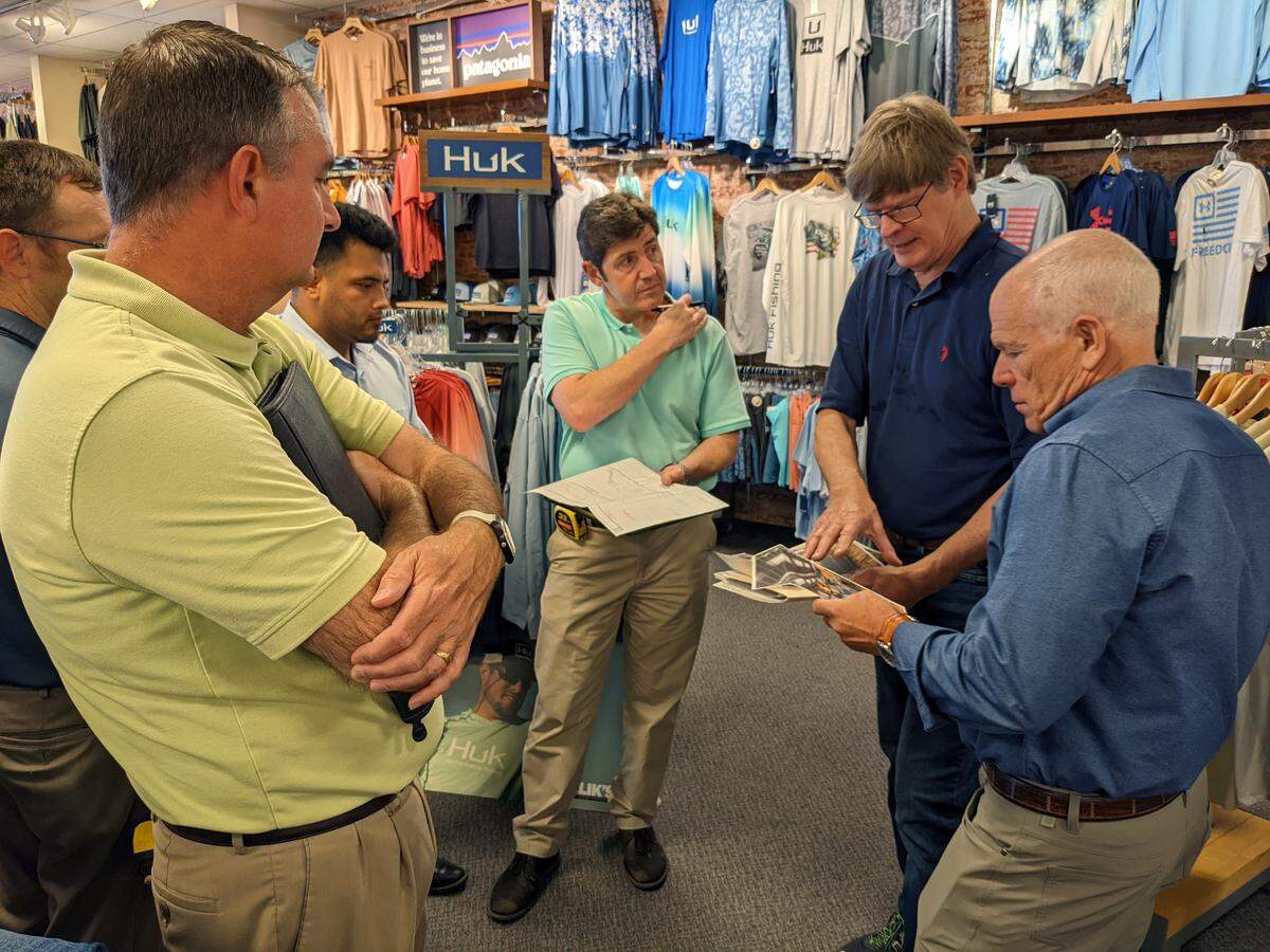 Glik’s President/CEO Jeff Glik (on right) looks through images of other stores’ layouts as he discusses plans for the Men’s Shop with the architectural team from The Korte Company.