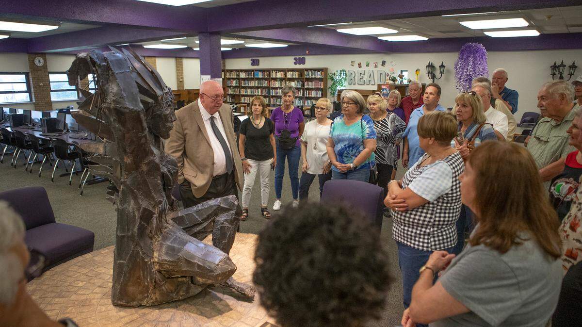 Members of the Collinsville High School Class of 1970 listen to President Mike Ray talk on Sept. 16 about an iron Kahok statue in the school library that the class donated more than 50 years ago.