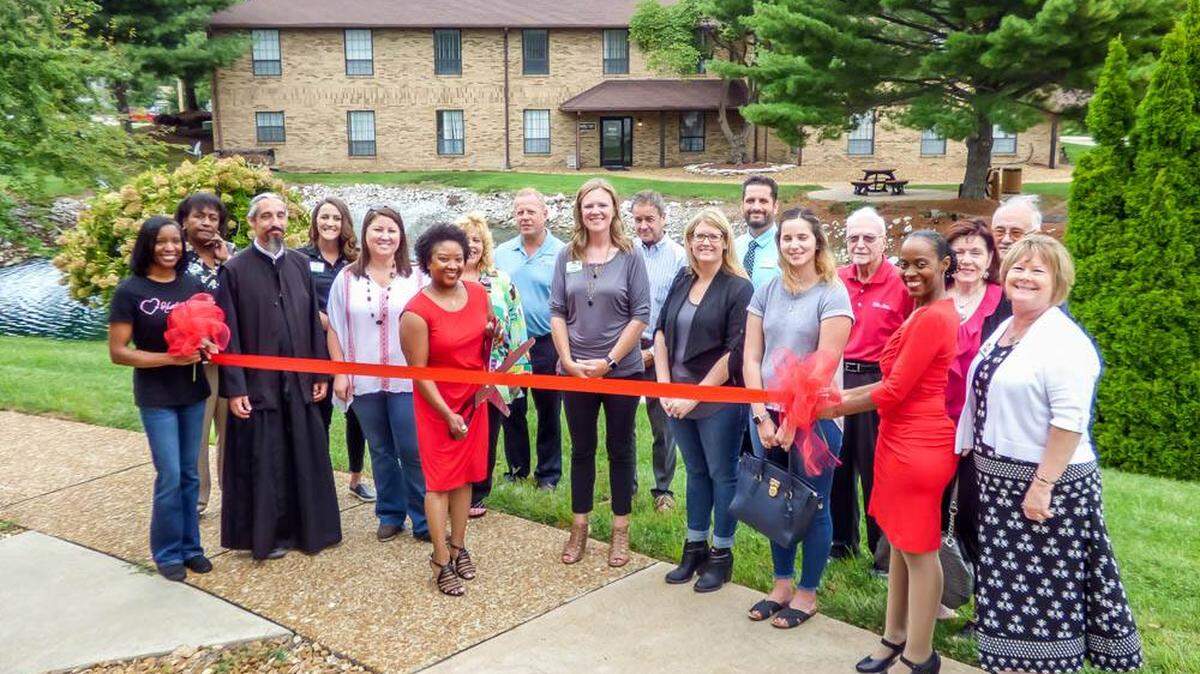 Leslie Davis cuts the ribbon during a ceremony for the Hearts in Faith office in O’Fallon. “I wanted to create a community of support for single moms,” Davis said of the nonprofit group she founded.