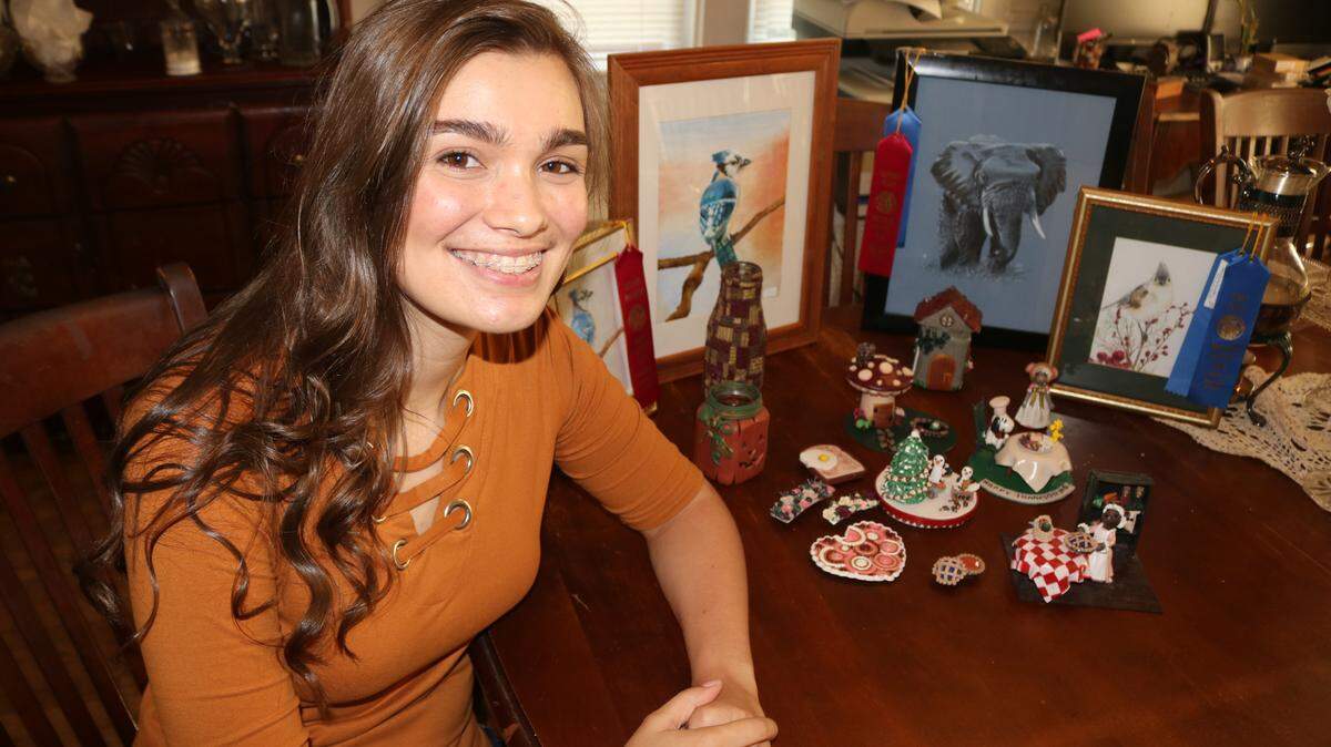 Ciara Paubel, 19, sits in front of various pieces of her artwork. While her focus is on polymer clay sculpting, Ciara also draws and paints. Ciara was recently commissioned for an illustration in Focus on the Family’s publication Clubhouse Magazine.