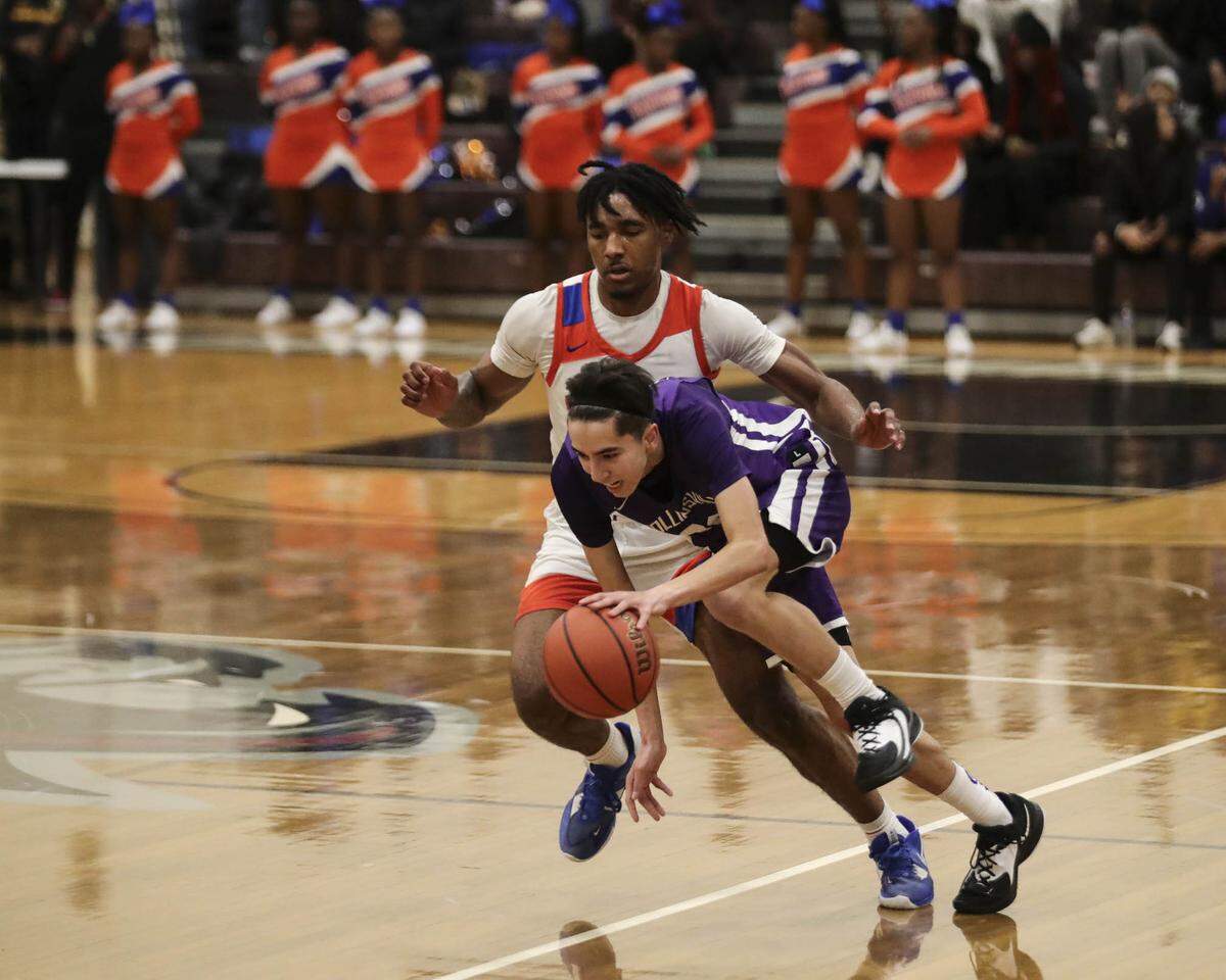 Collinsville’s Jake Wilkinson drives around an East St. Louis defender during Friday night’s Southwestern Conference game against East St. Louis. The Kahoks ultimately posted a 56-49 victory.