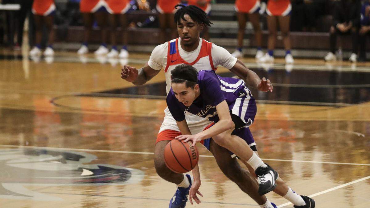 Collinsville’s Jake Wilkinson drives around an East St. Louis defender during Friday night’s Southwestern Conference game against East St. Louis. The Kahoks ultimately posted a 56-49 victory.
