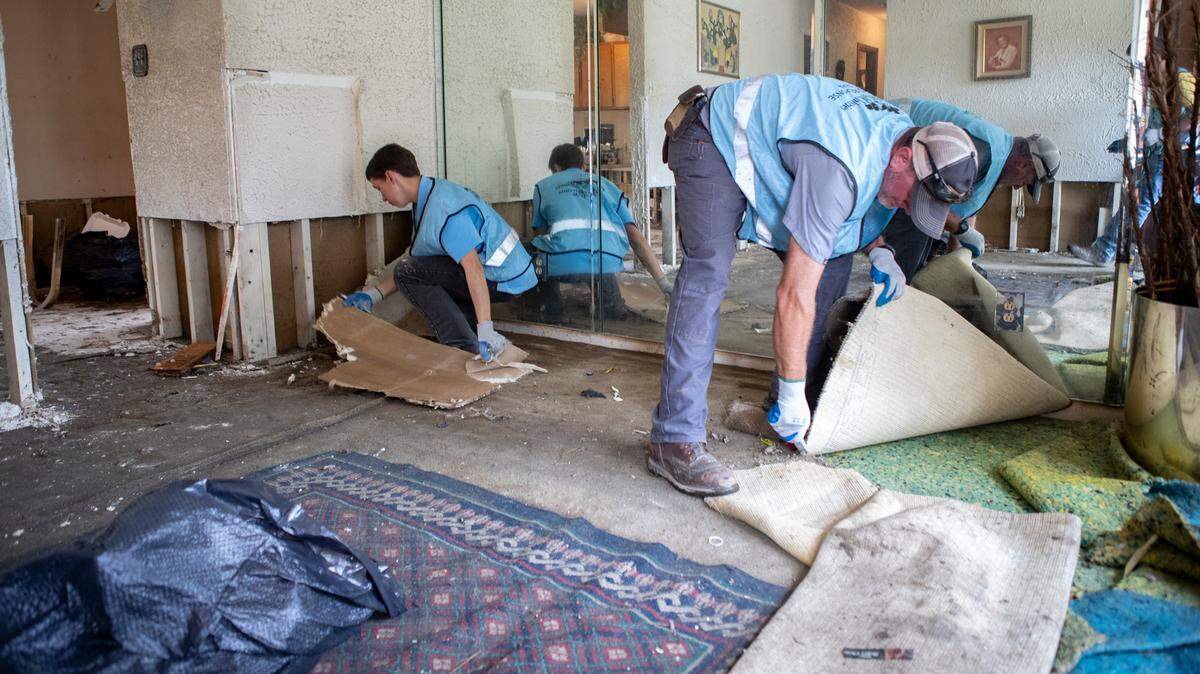 Titus Kuhns, Kenny Yoder and other volunteers with Christian Aid Ministries rapid response team remove damaged drywall, carpet, flooring and other items from flooded homes in the Terrace Dr. and Mary Ave. neighborhood in East St. Louis on Tuesday. The organization had about 20 volunteers from Ava and Arthur, Illinois regions.