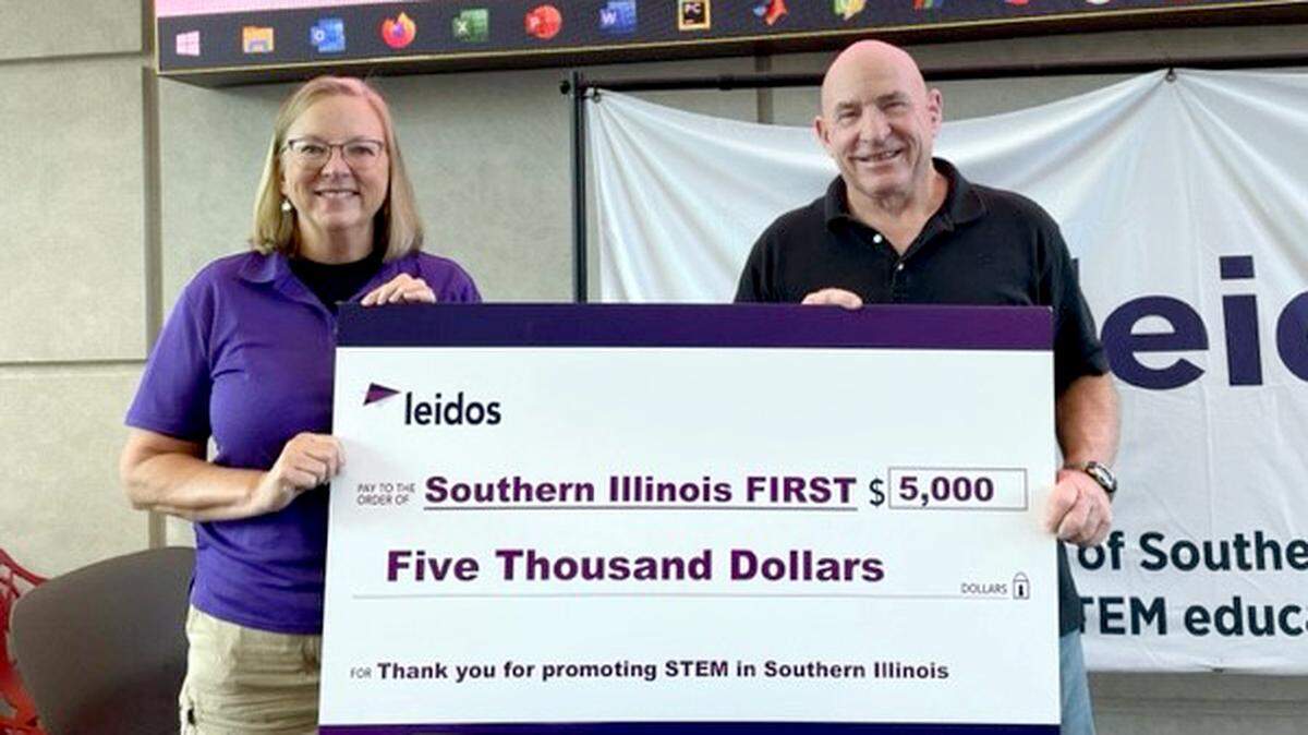 Leidos Supports Southern Illinois FIRST (For Inspiration and Recognition of Science and Technology) — Southern IL FIRST is a regional committee formed in 2014 to support the FIRST family of robotics programs in southern Illinois (Scott AFB Illinois local area). The mission of FIRST is to inspire young people to be science and technology leaders and innovators, by engaging them in exciting mentor-based programs that build science, engineering, and technology skills, that inspire innovation, and that foster well-rounded life capabilities including self-confidence, communication, and leadership. Leidos presented them with a $5,000 check at the First Technology Challenge season kick-off Saturday, Sept. 9. Pictured: Kathryn Lucas (Leidos Program Manager at Scott AFB) and Mike Harvey (Southern Illinois FIRST board member).