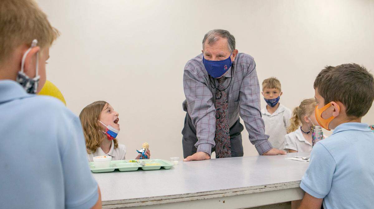 Principal Michael Kish visits with students during lunch on Thursday at Immaculate Conception Catholic School in Columbia.
