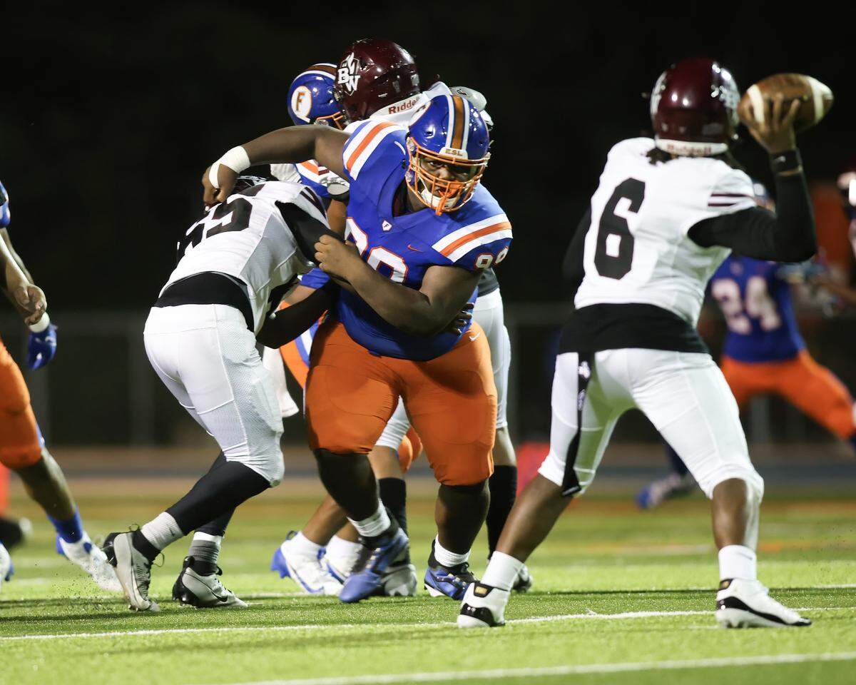 October 4, 2024 - East St. Louis Il, - East St. Louis defensive lineman Jayden Wheeler puts pressure on Belleville West quarterback Bernard Chapman during Friday night’s Southwestern Conference matchup between Belleville West and East St. Louis. [Photo: Chris Johns]